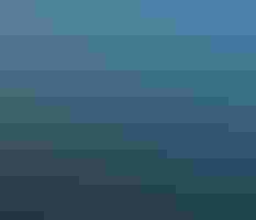 Aerial landscape of a forest consumed by fire, a huge area of trees already burned and the sky filled with clouds of smoke.