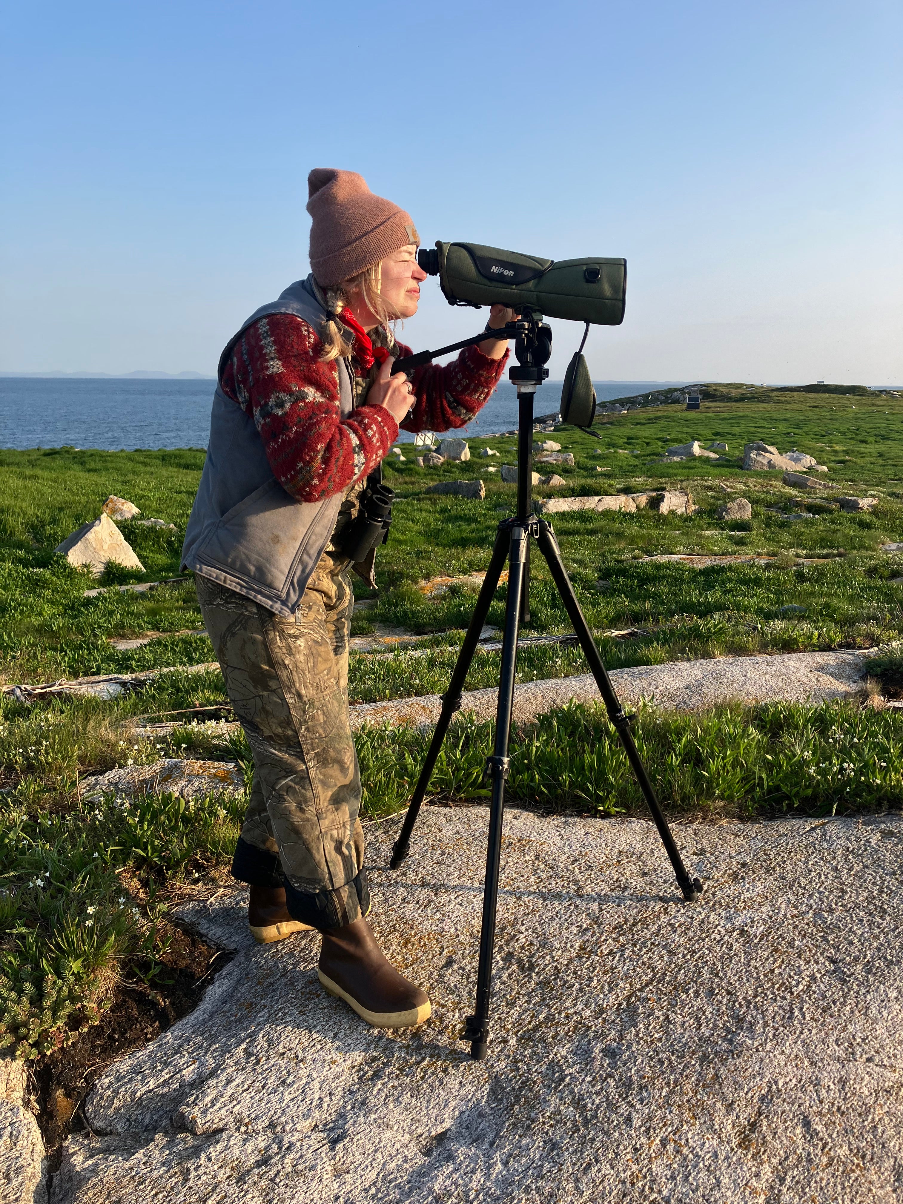 Celeste Flahaven looks through a scope while on Seal Island, Maine.