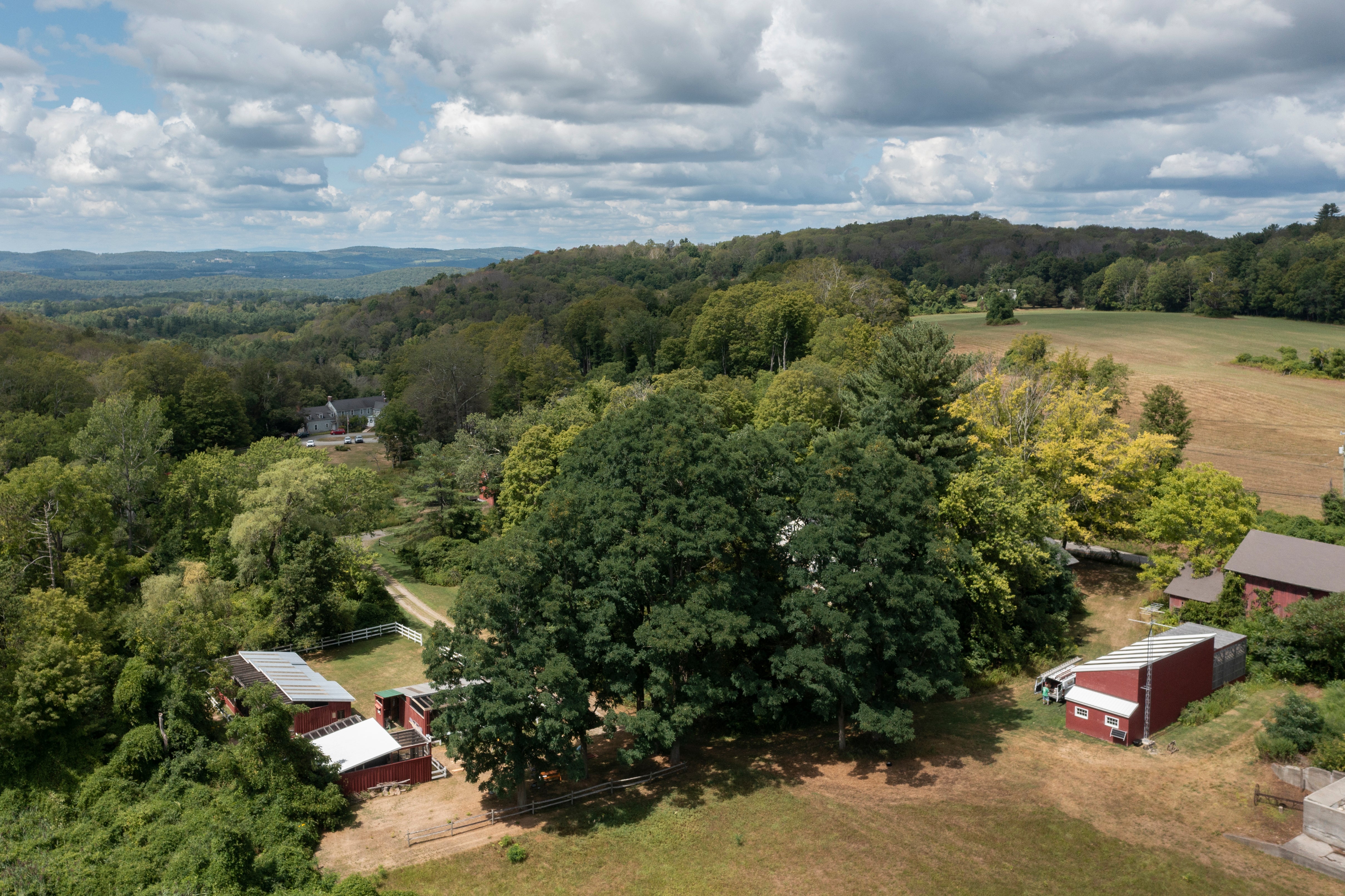 Overhead view of Sharon Audubon Center with red buildings and tree canopy