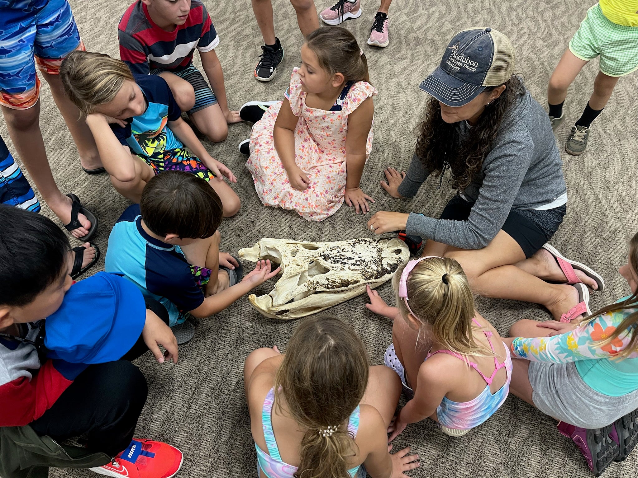 A group of children gathered around an alligator skull