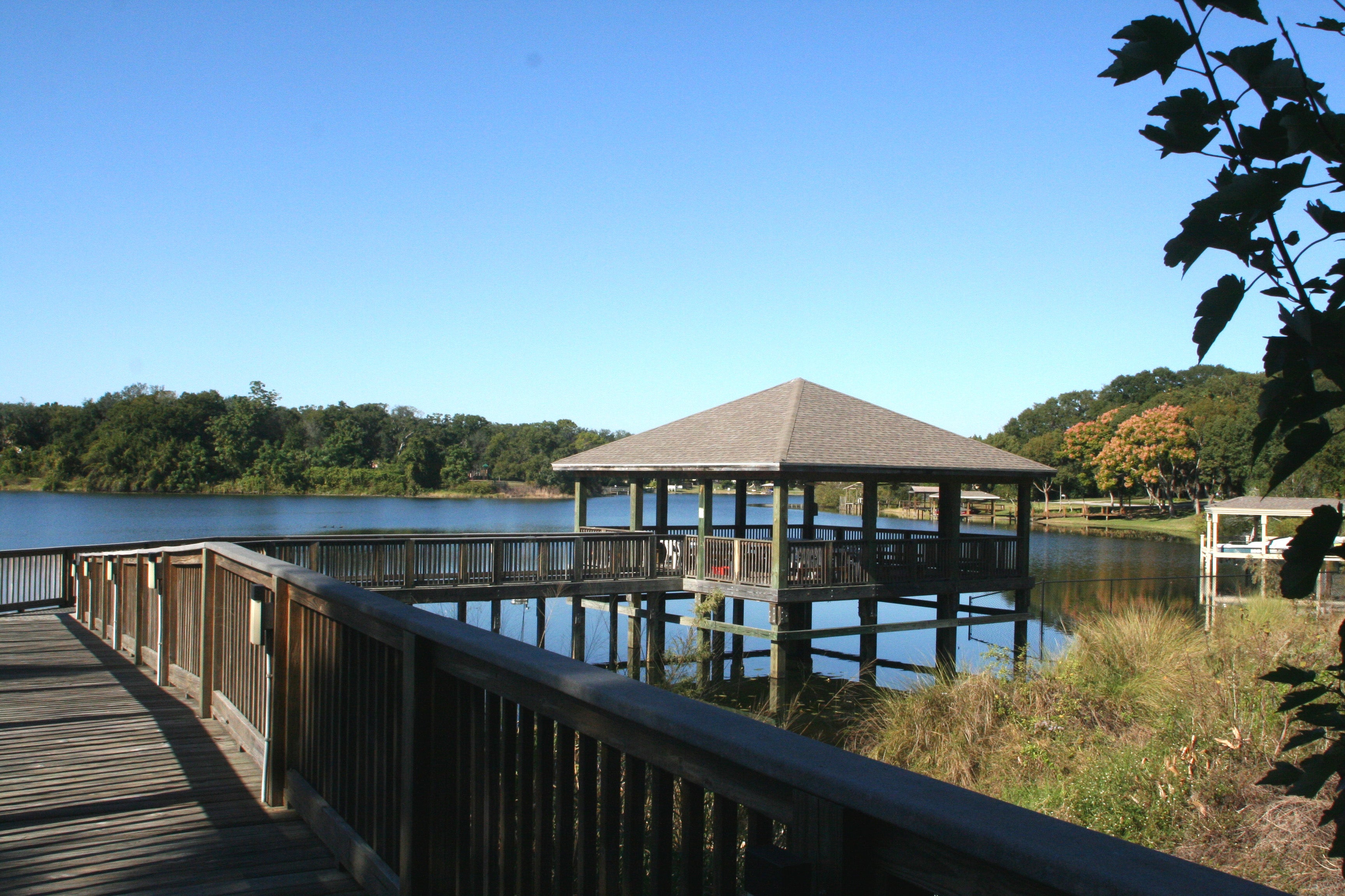 A boardwalk leading to a gazebo overlooking a lake.