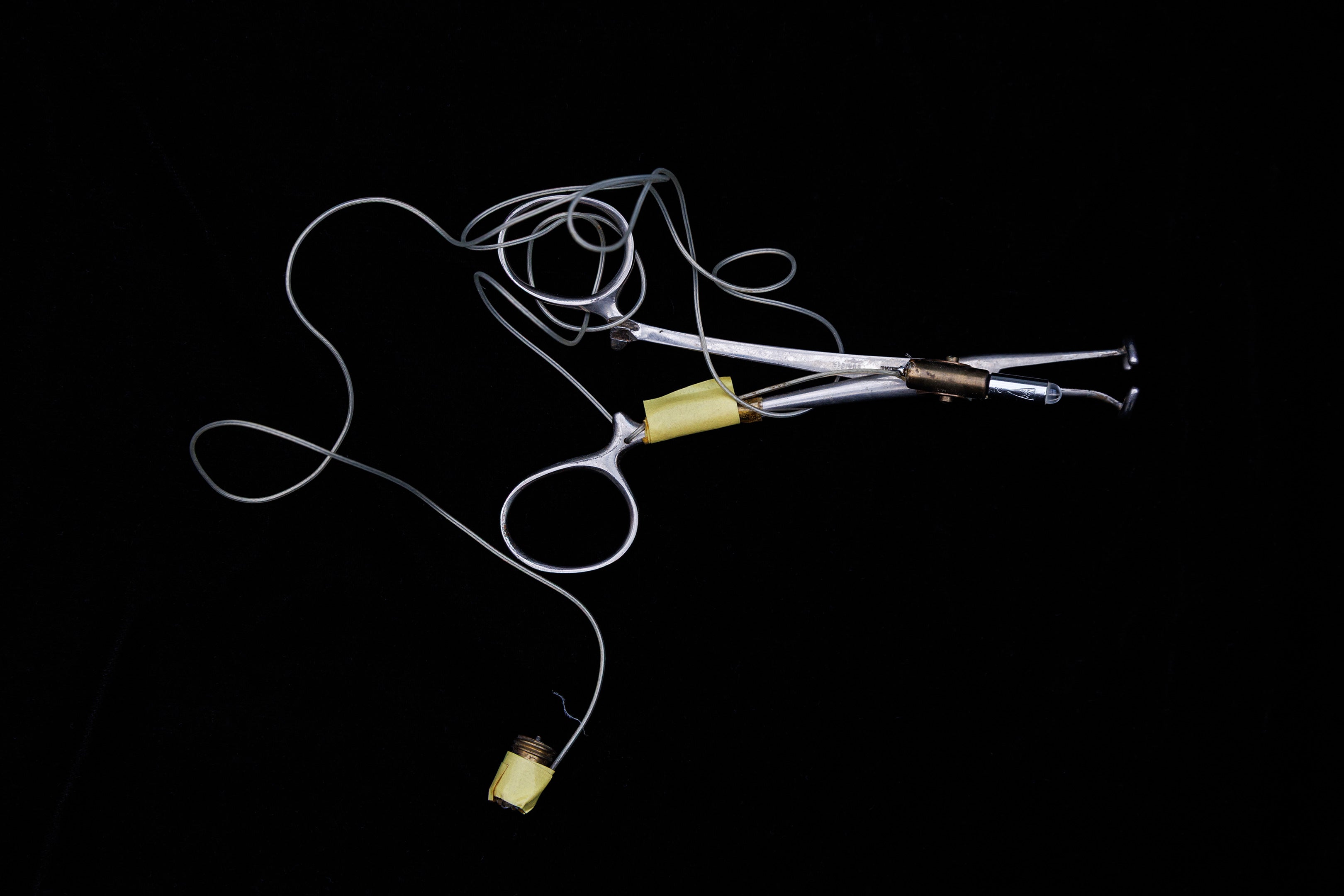 A metal instrument called a cloacascope on a black background.