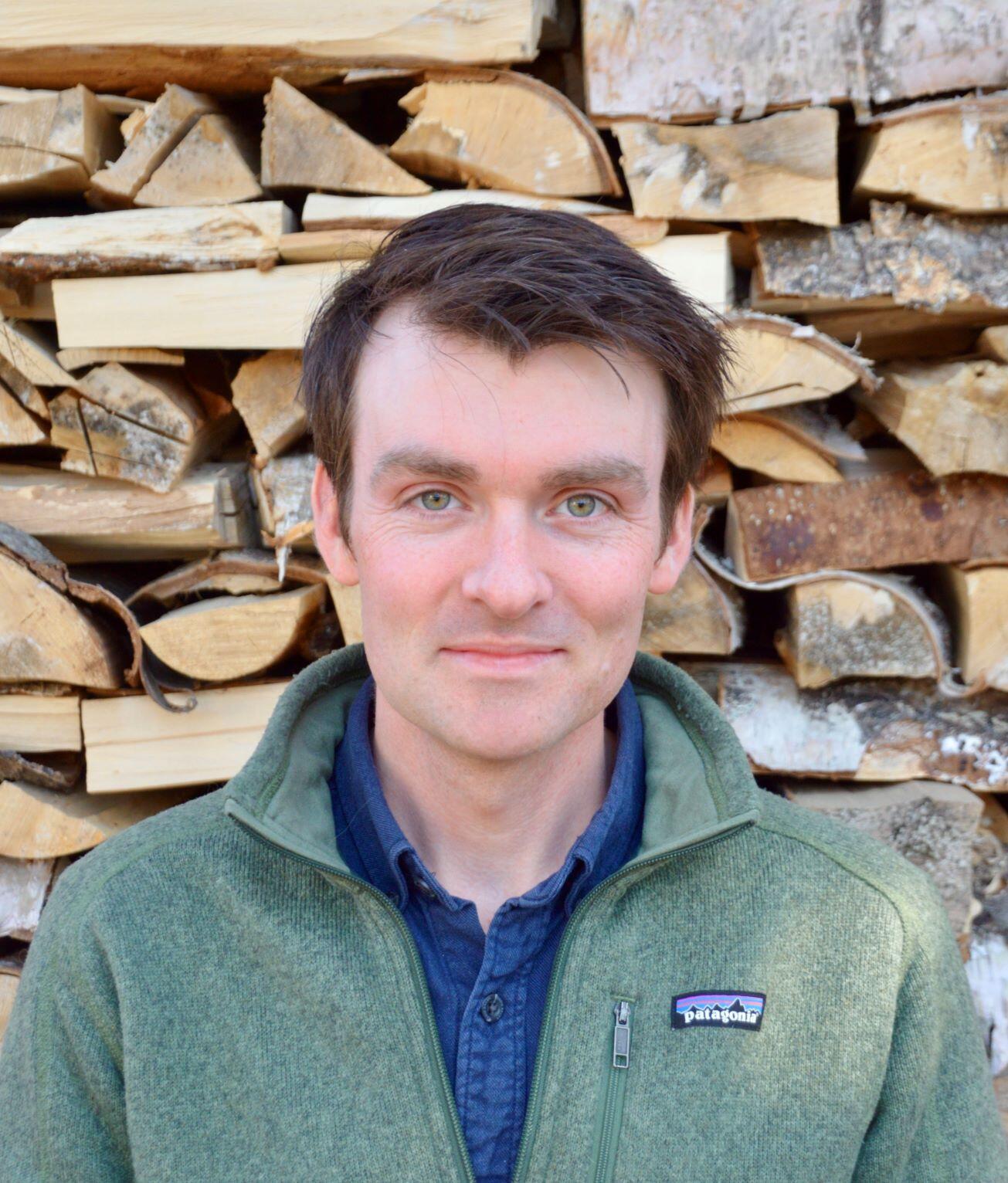 Man standing in front of cut wood