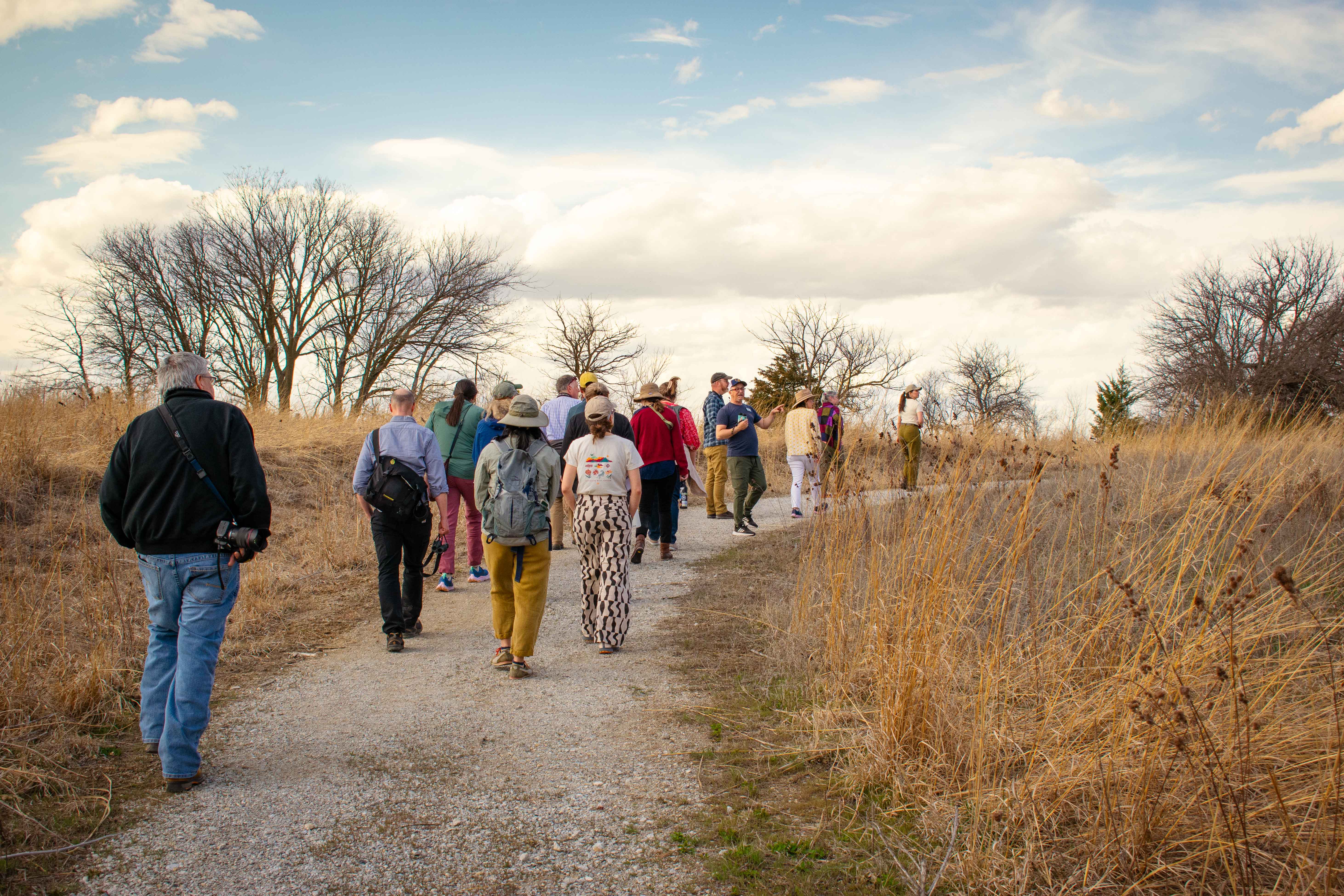 A group of people outside in the fall along a trail