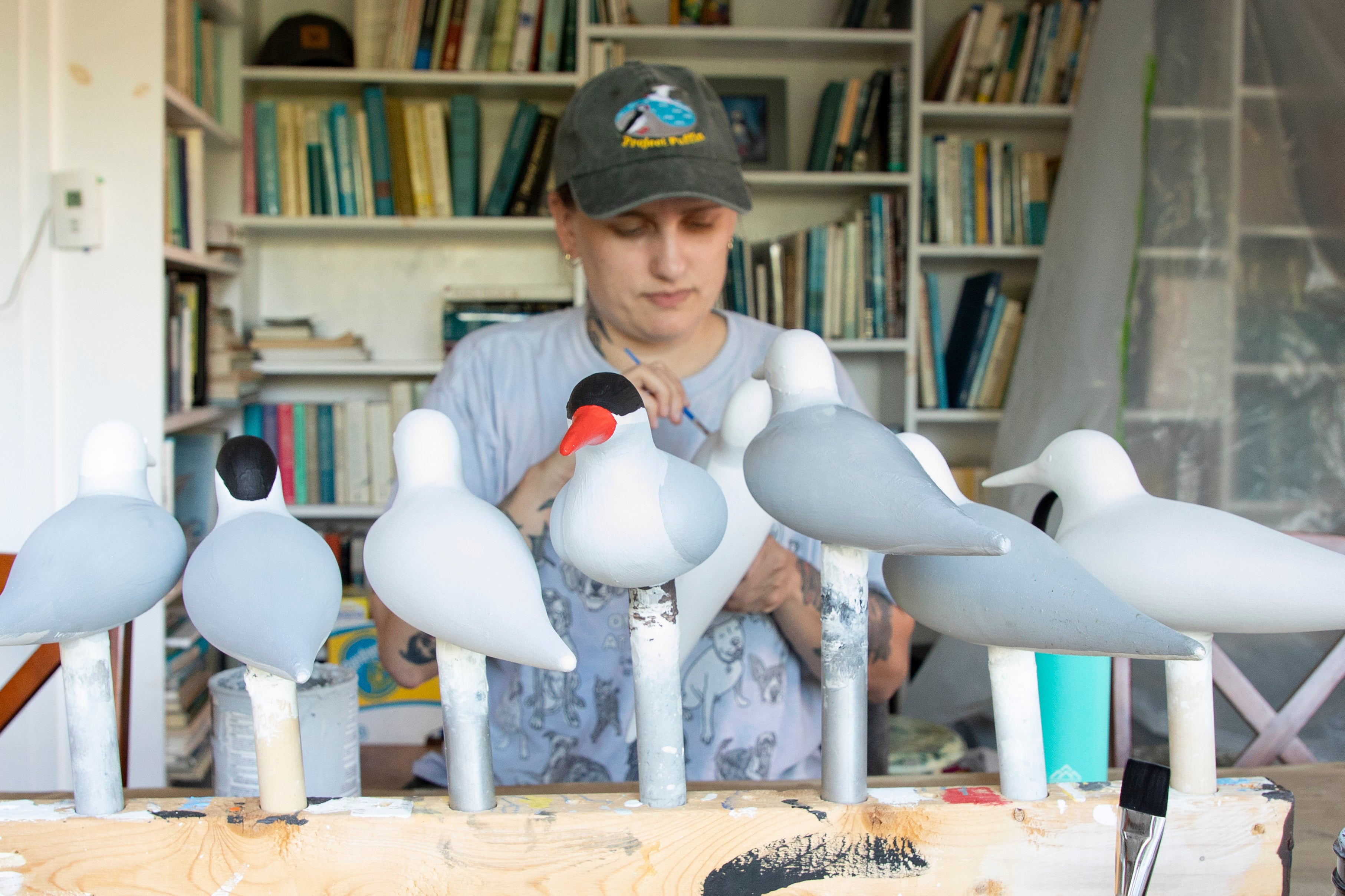 A person painting seabird decoys.