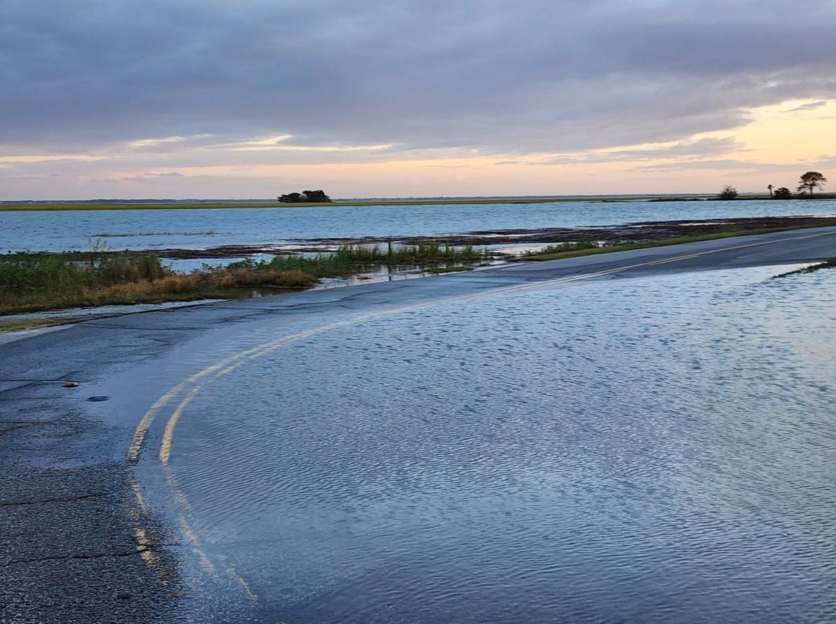 a road is underwater near a salt marsh