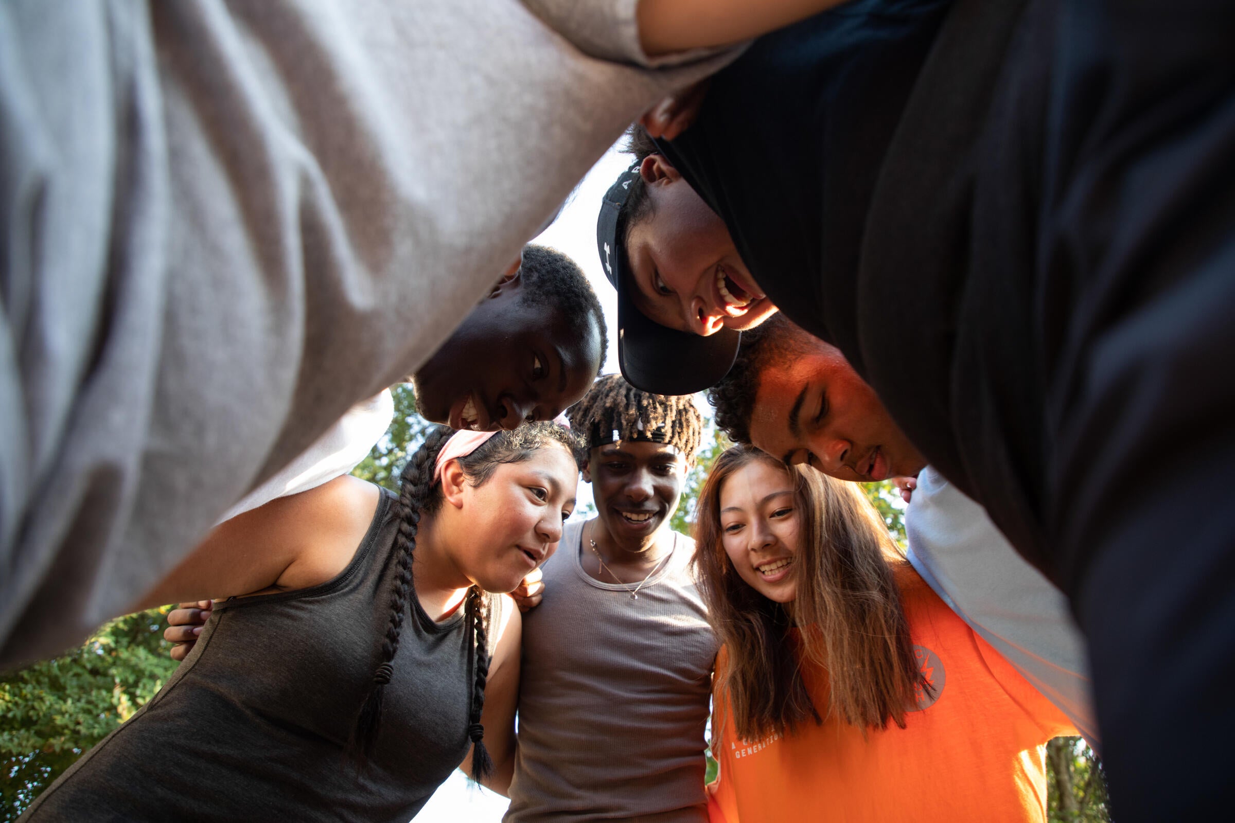 Teenagers huddle in a circle.