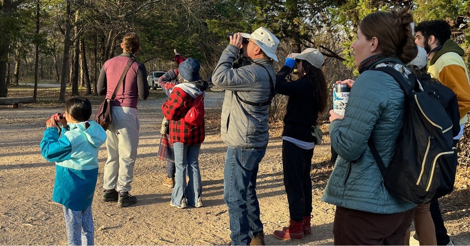 People birding on a trail. 