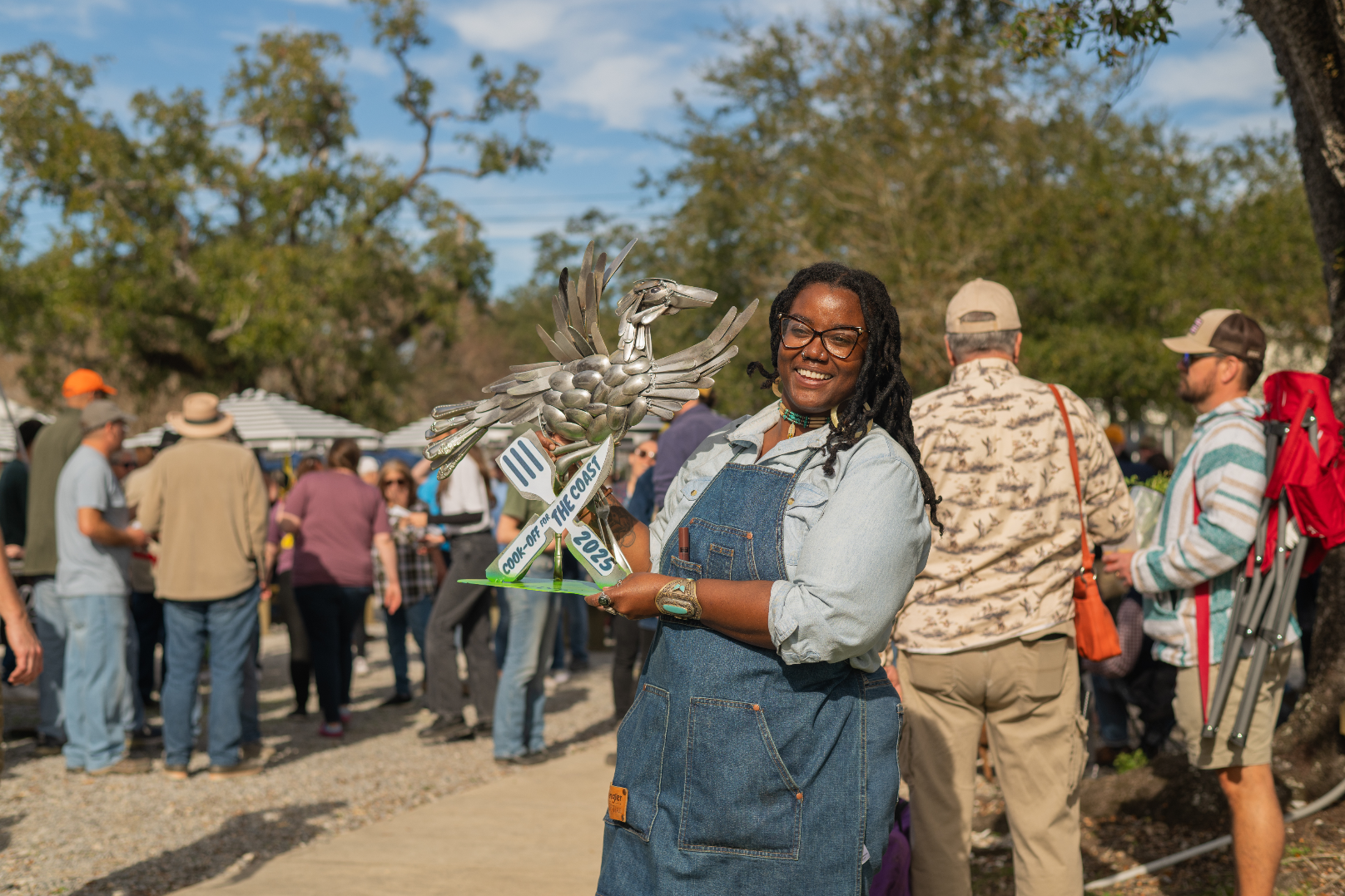 Aloe Lee holds a trophy at Cook-off for the Coast while smiling