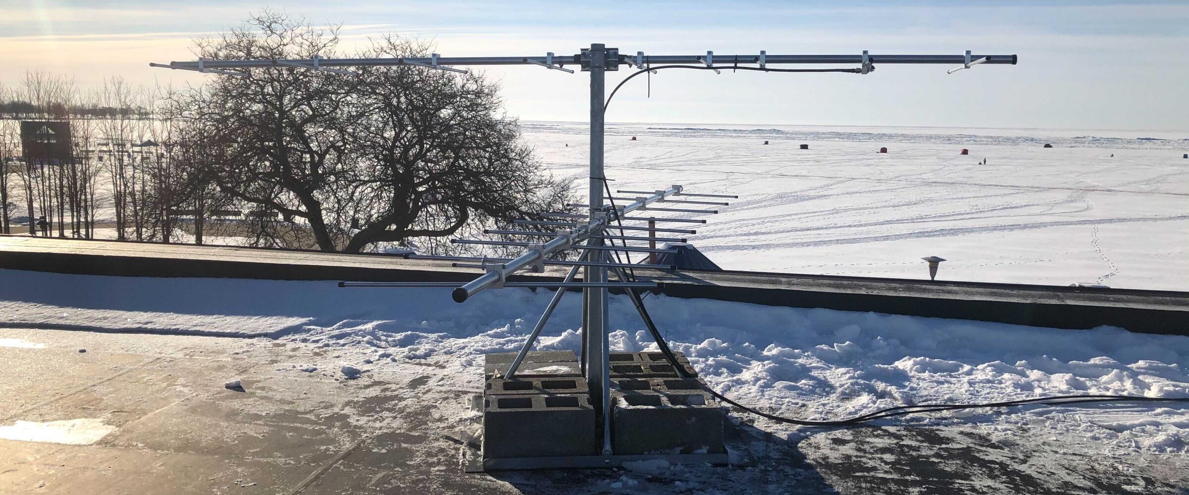 Wildlife tracking system receiver tower in Michigan, with snow on the ground.