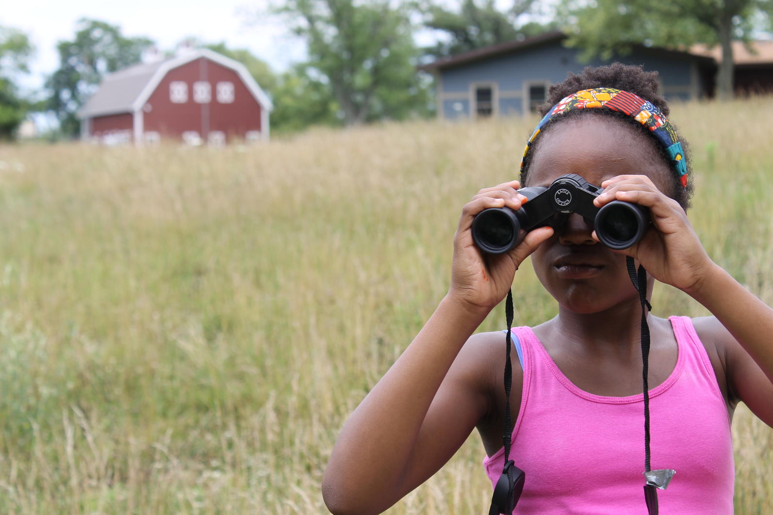 Young Wild Indigo participant looks through binoculars.