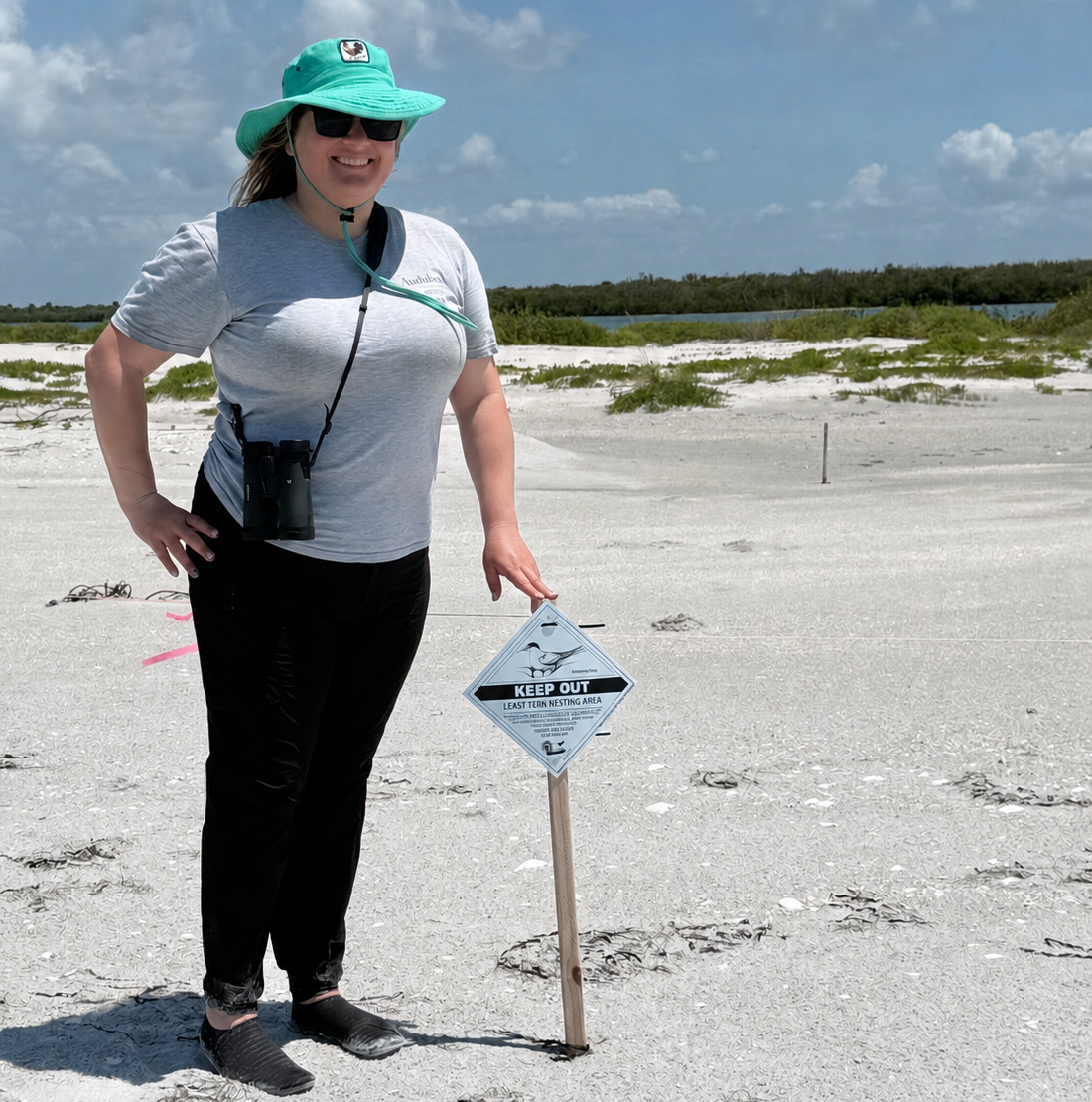 whitney standing in front of a beach bird sign 