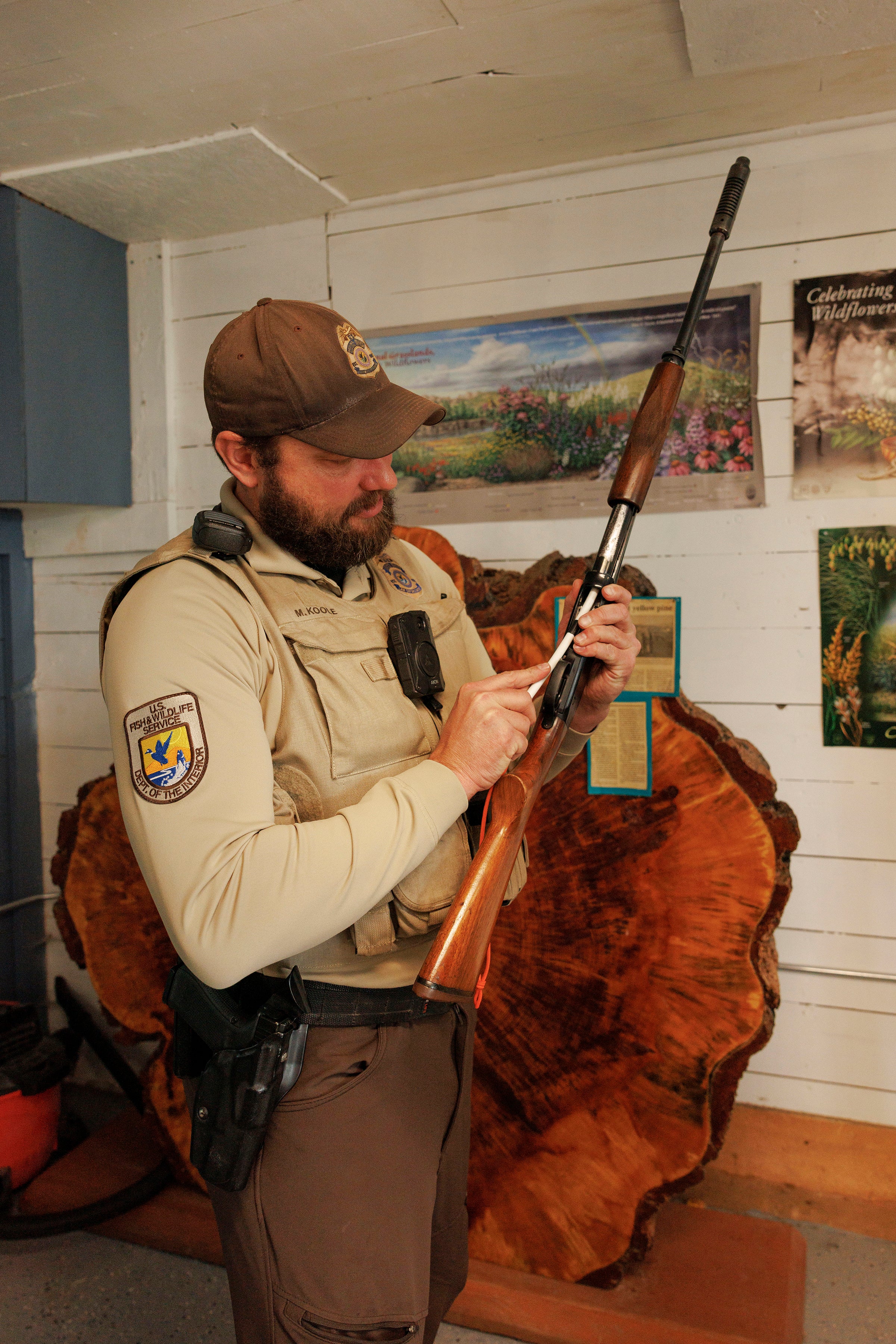 An officer demonstrates how to check how many shells are in a shotgun.