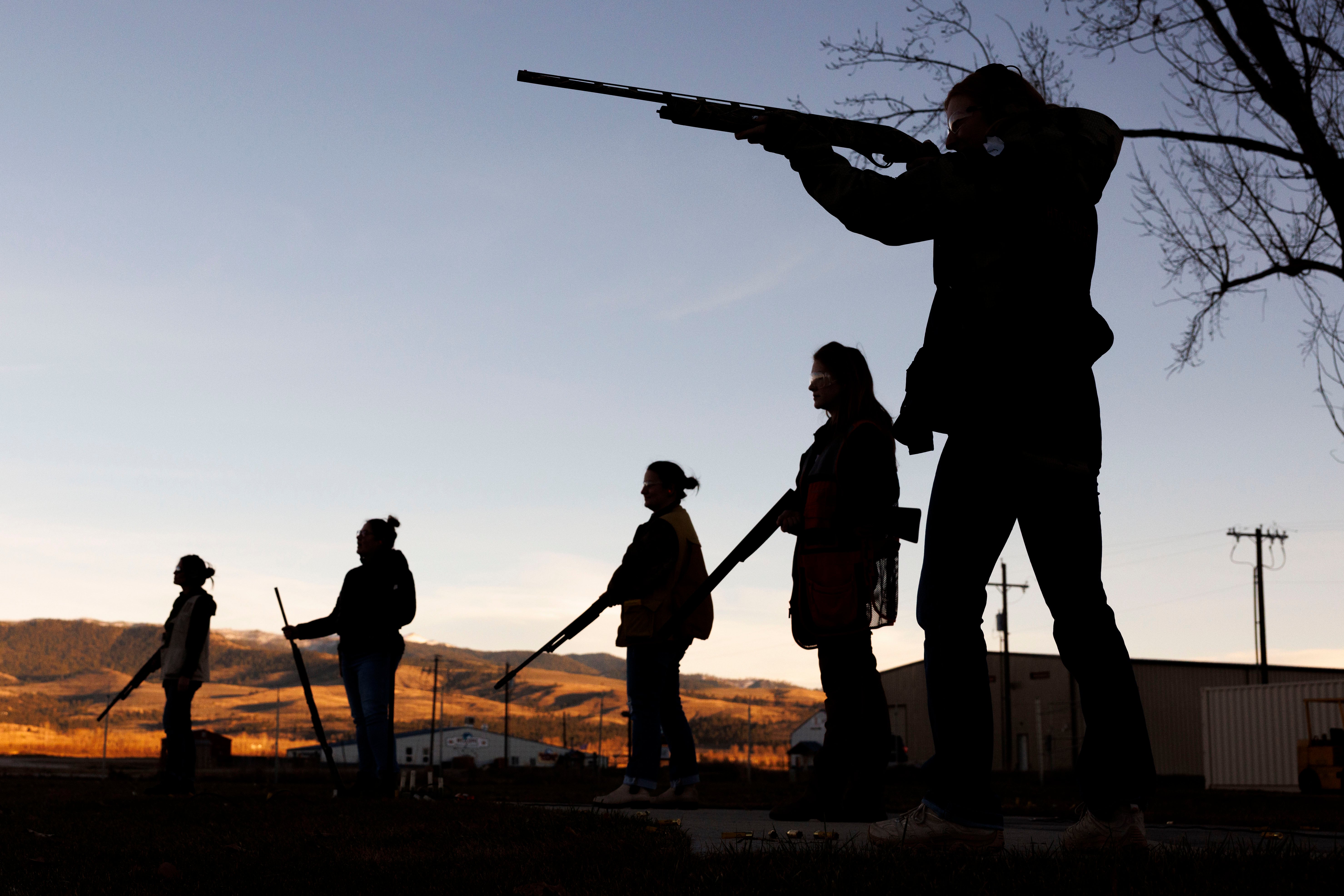 The silhouettes of five people shooting.