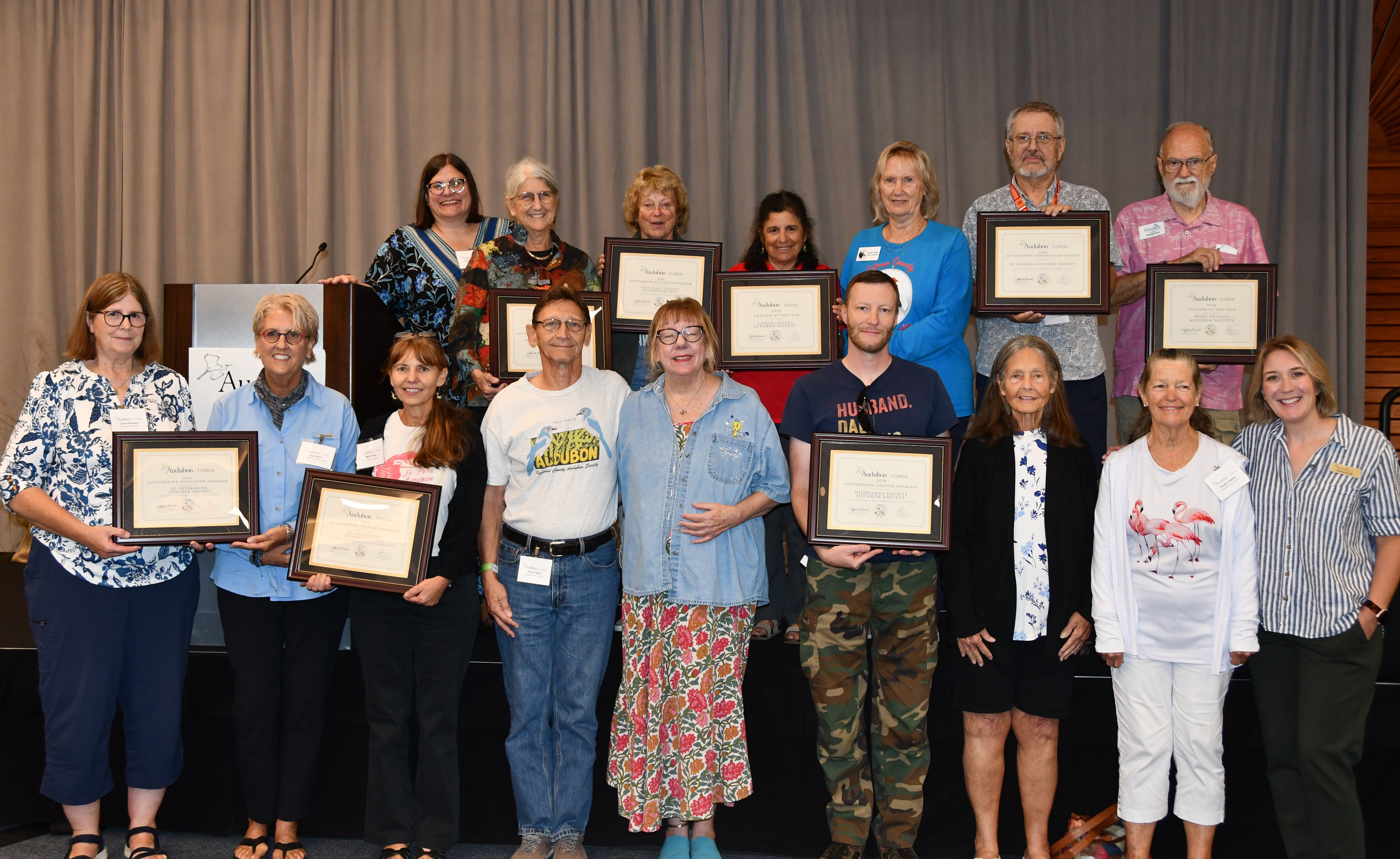 A group of people with plaques on a stage