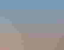 A lake is held by a dam in a dry landscape.