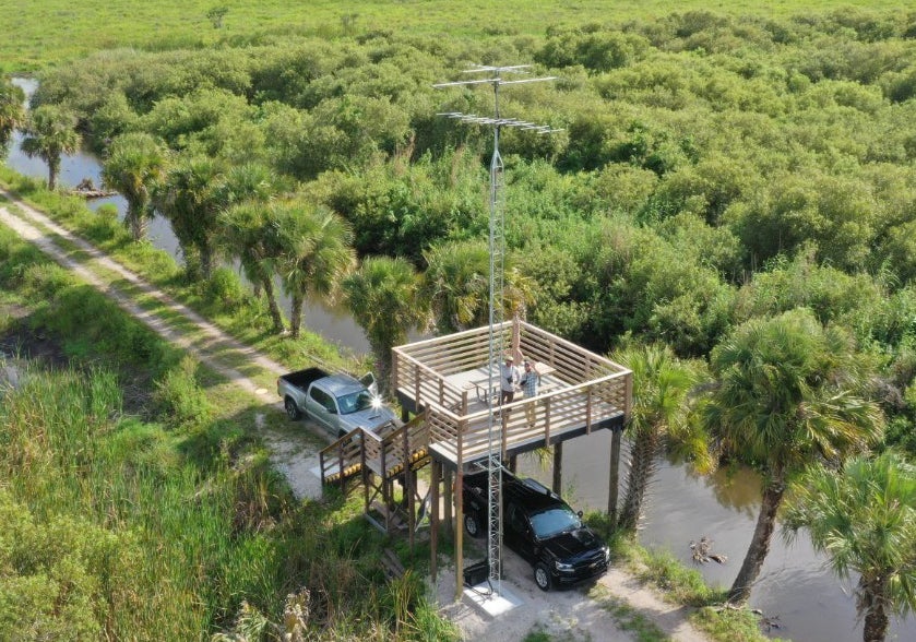 A wooden structure with metal tower surrounded by wilderness
