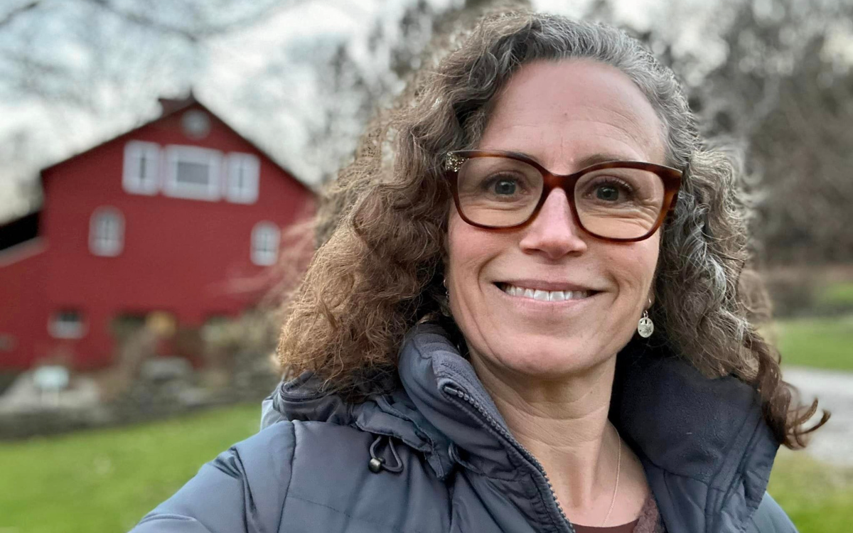 Selfie of Senior Center Manager Robin Ladouceur standing in front of the Bent of the River center building, smiling.