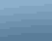 View of an island with trees behind rows of white structures in the water