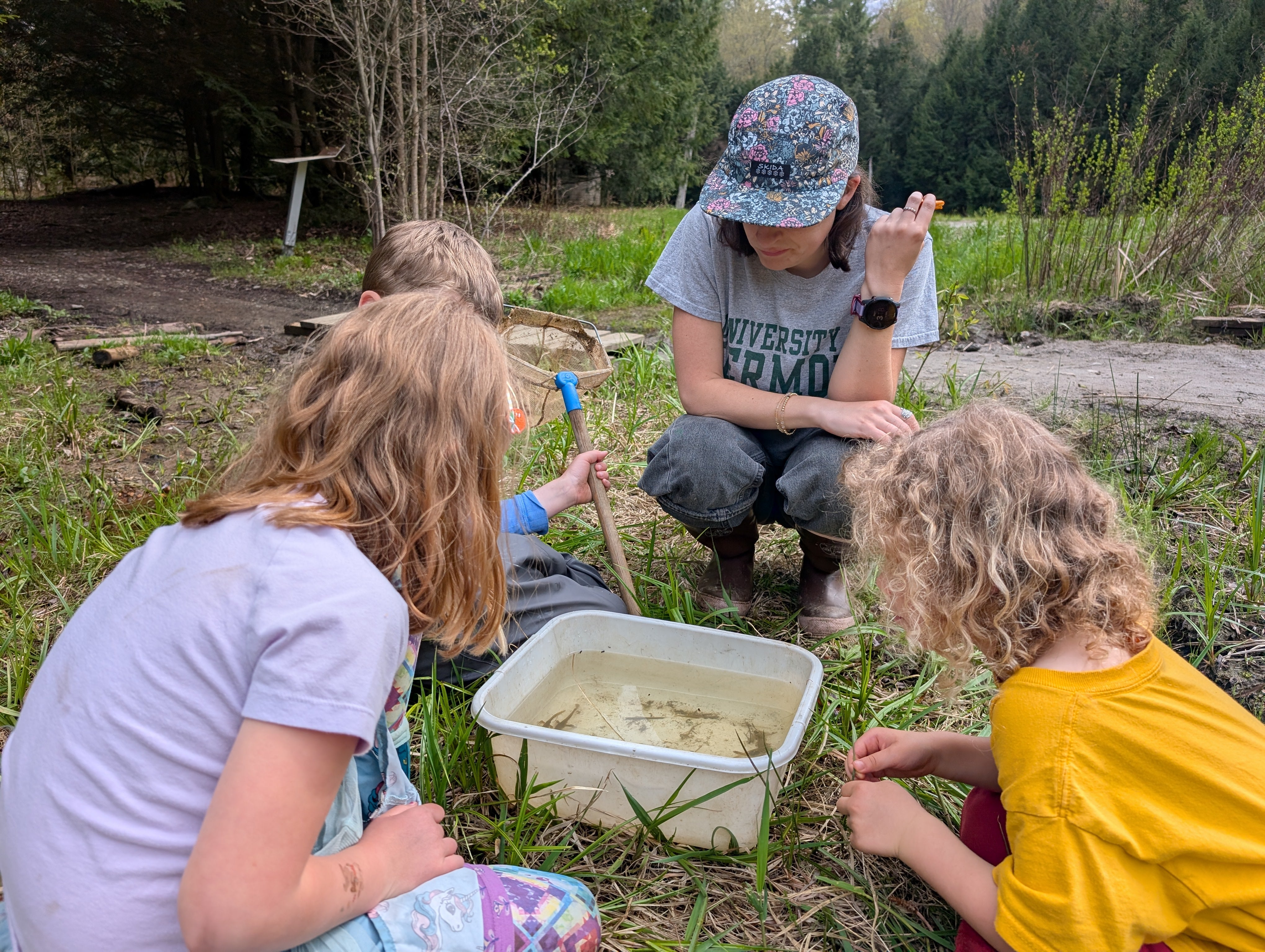 Zoe looking at critters from Beaver Pond with Afterschool students.