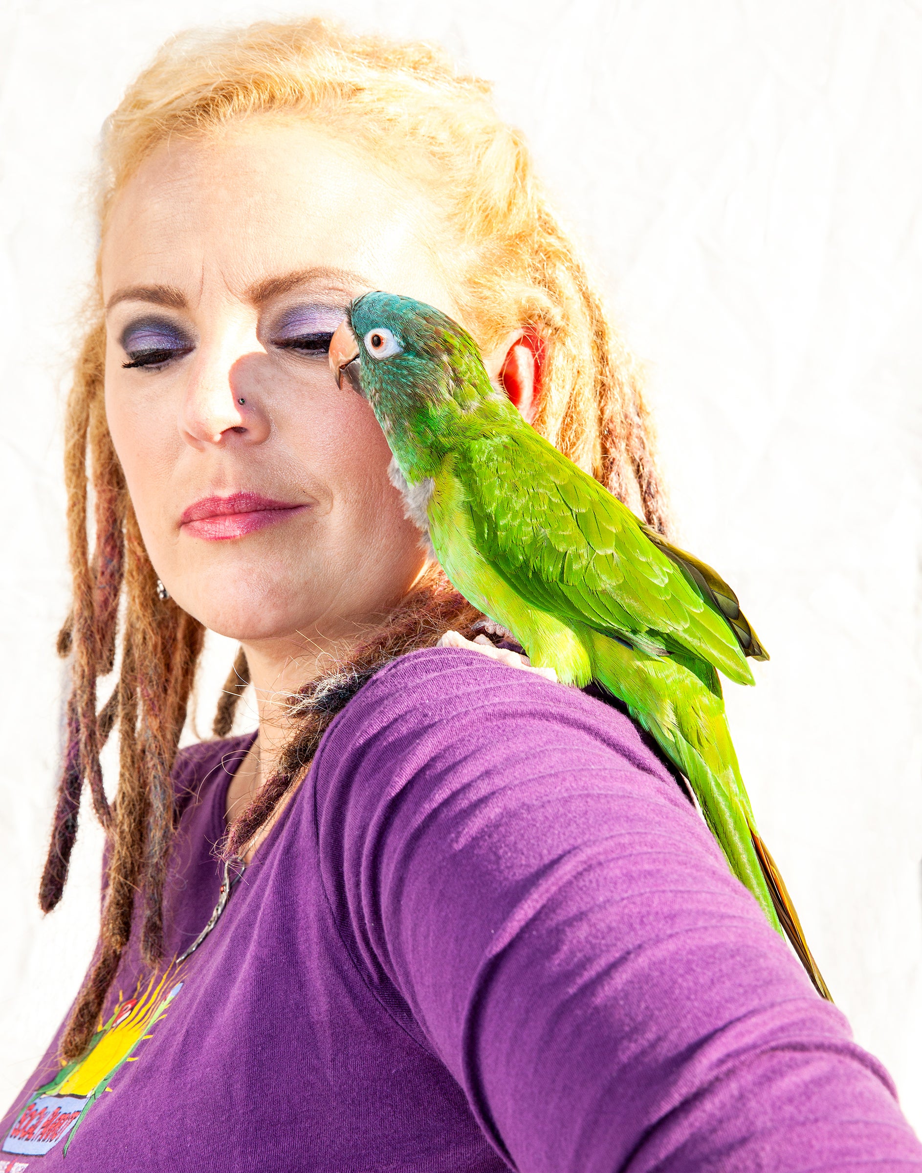 Since 2007 Durham (with a Blue-crowned Parakeet) has opened her home to parrots suffering from various injuries, including electrocution, pellet-gun wounds, and broken wings. Tom Fowlks