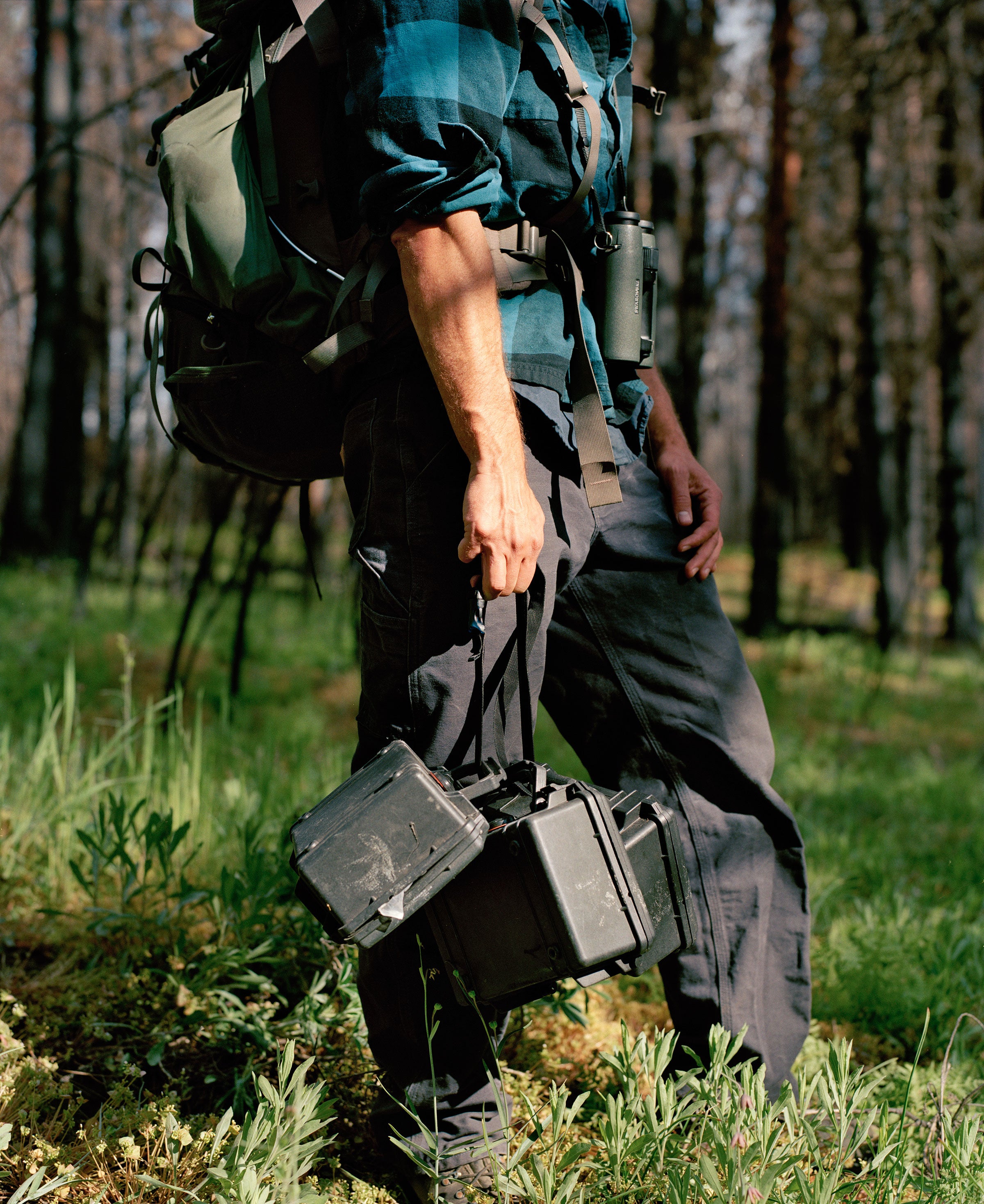 Joe Medley carries recording equipment to set up in a meadow. Jake Stangel