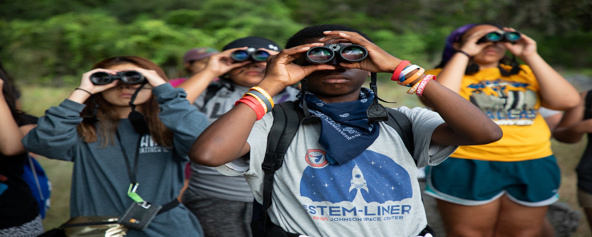 High school students birding at Lost Maples State Natural Area during a week-long outdoor Conservation Trek hosted by Trinity River Audubon Center. Photo: Luke Franke/Audubon A group of people holding binoculars