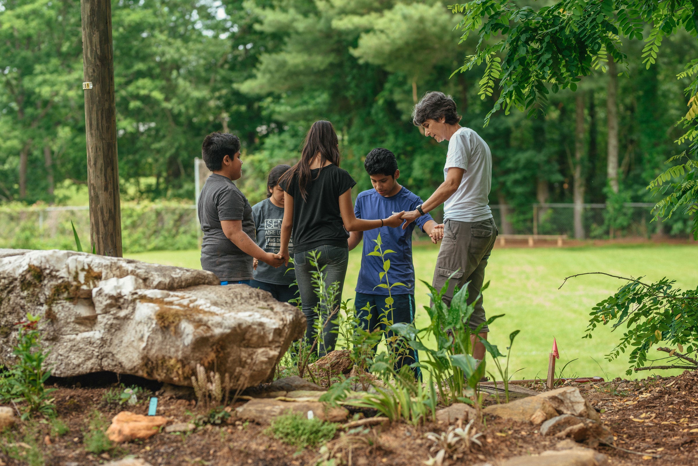 Volunteers from St. Eugene Catholic Church pray together after planting native plants in the Friendship Garden. Mike Belleme