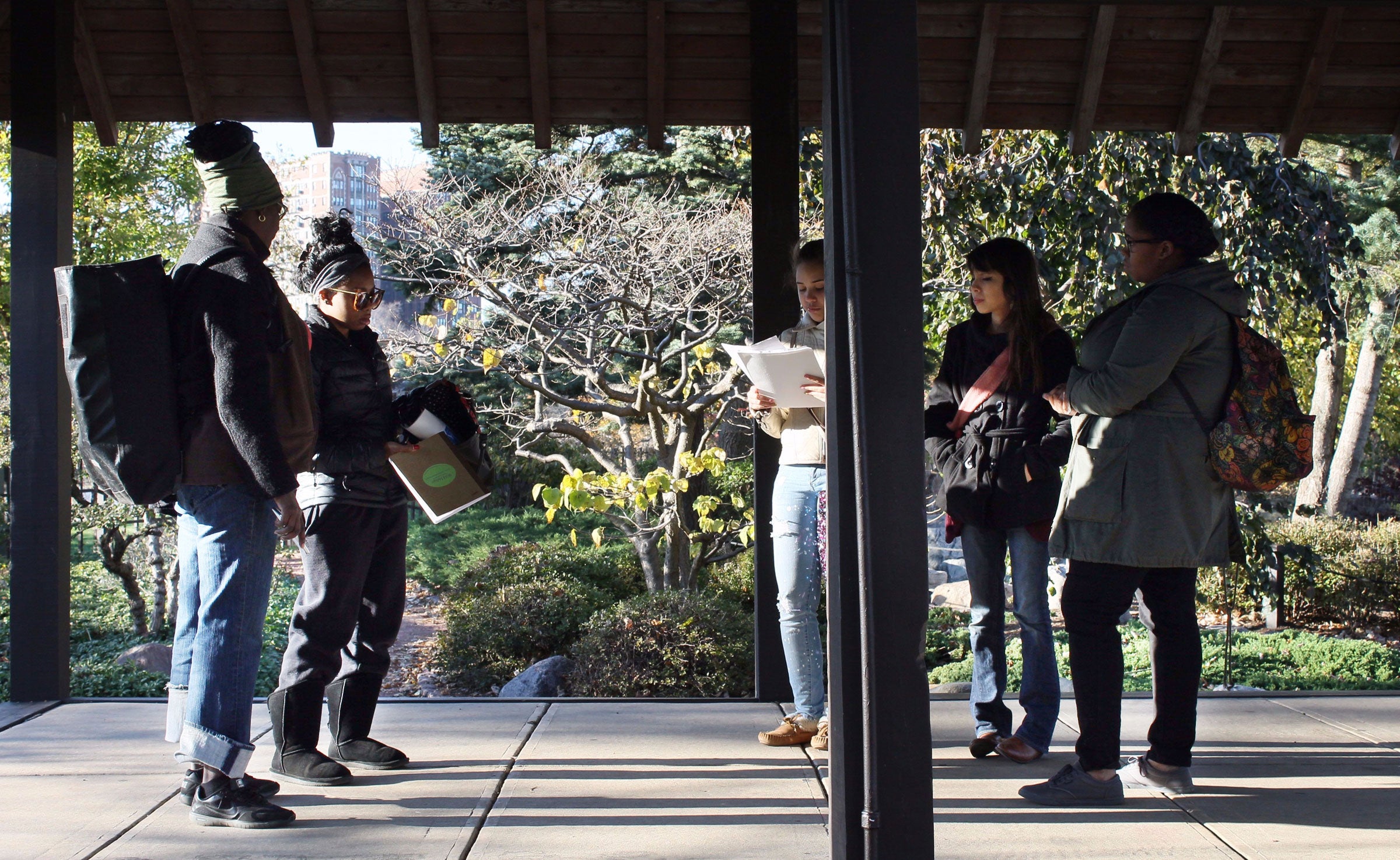 Four fellows (Abrianna Carter, Samantha Williamson, Ivonne Chavez, Jaharha Pryor) plus instructor Anayansi Ricketts, sharing info learned about Jackson Park, in the park’s Osaka Garden. Troy Peters
