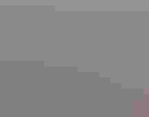 A blanket of snow coats the roads and roofs of rows and rows of houses. The neighborhood is seen in an aerial view.